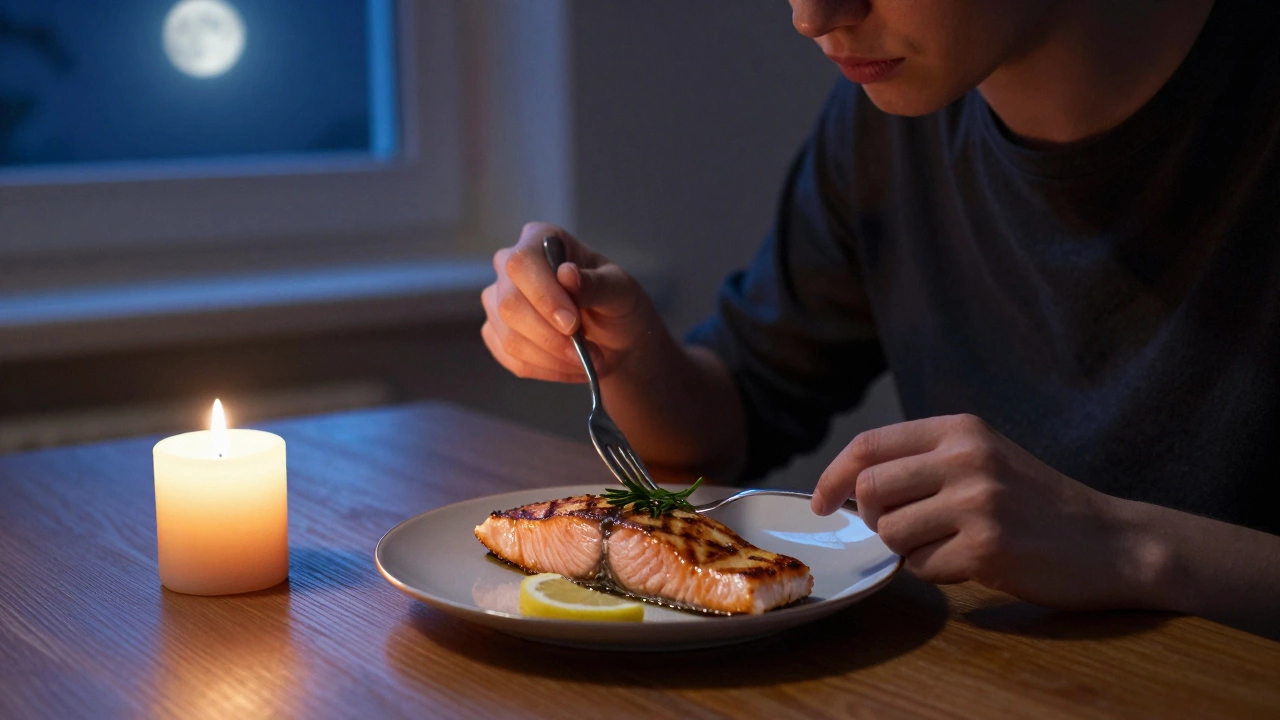 A person eating grilled salmon at night with candlelight and moonlight.